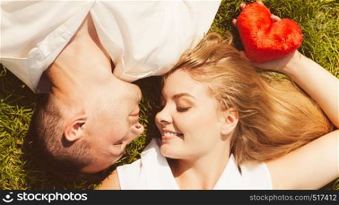 Relationship goals, love forever concept. Man and woman lying on grass having date, enjoying spending romantic time together. Man and woman lying on grass having date