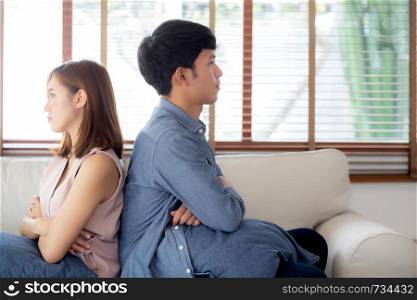 Relationship of young asian couple having problem on sofa in the living room at home, family having conflict argument with unhappy, man and woman with issue, failure and stress together.