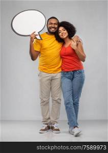 relationships and people concept - happy african american couple holding blank speech bubble over grey background. african american couple with blank speech bubble