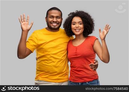 relationships and people concept - happy african american couple hugging over grey background. happy african american couple hugging