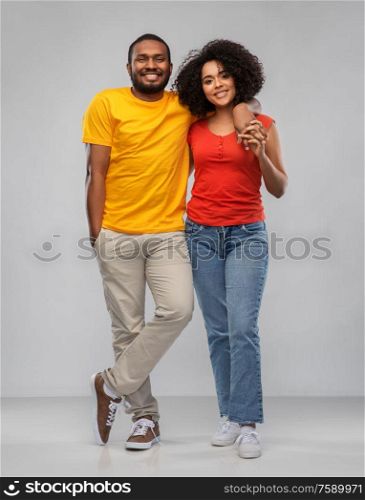 relationships and people concept - happy african american couple hugging over grey background. happy african american couple hugging