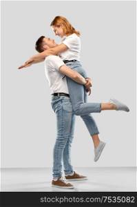 relationships and people concept - happy couple in white t-shirts over grey background. happy couple in white t-shirts