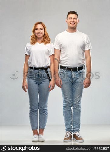 relationships and people concept - happy couple in white t-shirts over grey background. happy couple in white t-shirts