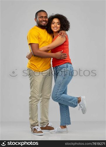 relationships and people concept - happy smiling african american couple hugging over grey background. happy african american couple hugging
