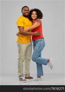 relationships and people concept - happy smiling african american couple hugging over grey background. happy african american couple hugging