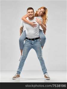relationships and people concept - portrait of happy couple in white t-shirts having fun over grey background. happy couple in white t-shirts having fun