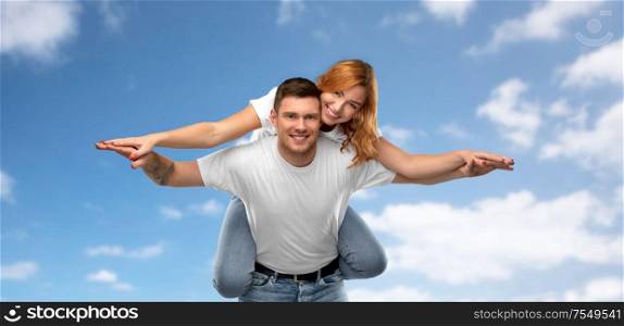 relationships and people concept - portrait of happy couple in white t-shirts having fun over blue sky and clouds background. happy couple in white t-shirts having fun