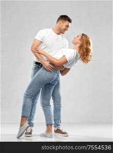 relationships and people concept - portrait of happy couple in white t-shirts dancing over grey background. portrait of happy couple in white t-shirts dancing