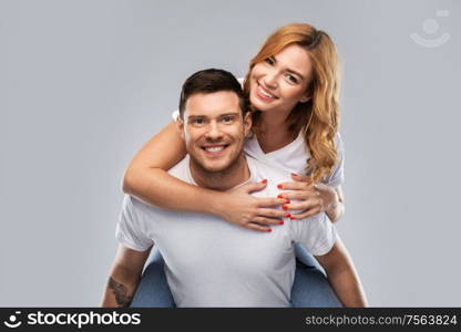 relationships and people concept - portrait of happy couple in white t-shirts having fun over grey background. happy couple in white t-shirts having fun