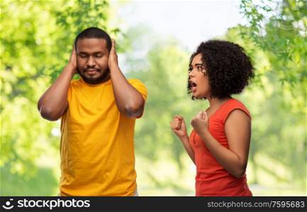 relationships and people concept - unhappy african american couple having argument over green natural background. african american couple having argument