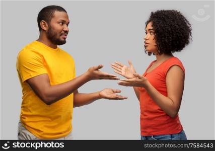 relationships and people concept - unhappy african american couple having argument over grey background. african american couple having argument