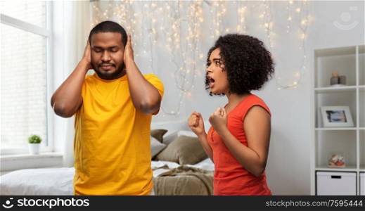 relationships and people concept - unhappy african american couple having argument over home bedroom background. african american couple having argument at home