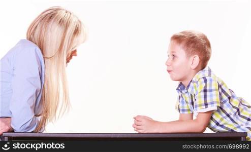 Relationships arguments and discussion. Mother and son sit at table and argue discuss solve problem.. Mother and son talk and argue sit at table.