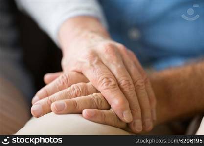 relationships, charity, old age and people concept - close up of senior couple holding hands. close up of senior couple holding hands