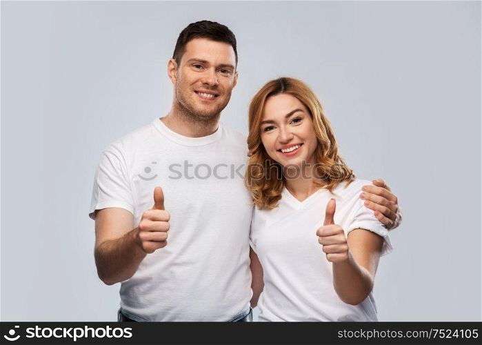relationships, gesture and people concept - portrait of happy couple in white t-shirts over grey background. portrait of happy couple in white t-shirts