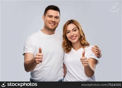 relationships, gesture and people concept - portrait of happy couple in white t-shirts over grey background. portrait of happy couple in white t-shirts