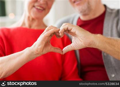 relationships, love and old people concept - close up of senior couple showing hand heart gesture. close up of senior couple showing hand heart sign
