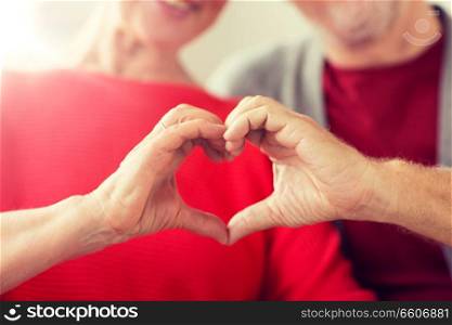relationships, love and old people concept - close up of senior couple showing hand heart gesture. close up of senior couple showing hand heart sign