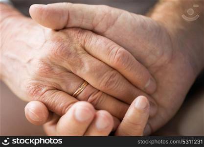 relationships, marriage and old people concept - close up of senior couple holding hands. close up of senior couple holding hands