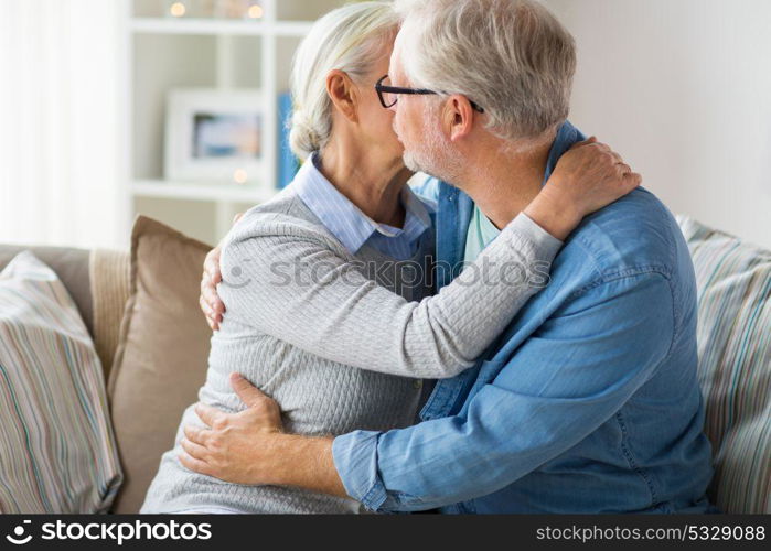 relationships, old age and people concept - close up of happy senior couple hugging and kissing at home. close up of happy senior couple hugging at home