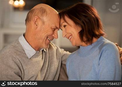 relationships, old age and people concept - happy smiling senior couple at home in evening. happy smiling senior couple at home