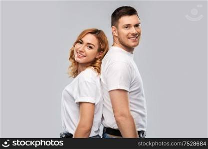 relationships, style and people concept - portrait of happy couple in white t-shirts over grey background. portrait of happy couple in white t-shirts