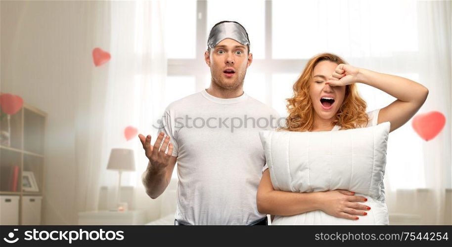 relationships, valentine&rsquo;s day and people concept - couple in white t-shirts with eye sleeping mask and pillow over home room decorated with heart shaped balloons background. couple with eye sleeping mask and pillow at home