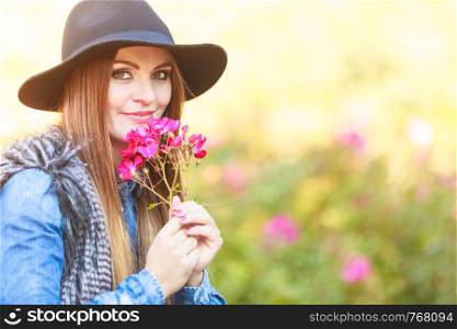 Relax and gardening. Lovely cute young woman spending time in garden. Cheerful beauty girl with pink flowers outdoor.. Young lady relaxing in garden