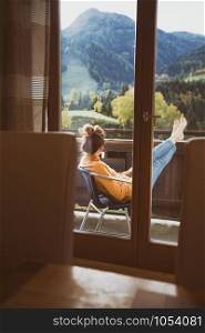 relax. girl sitting in a chair on a balcony with mountain views