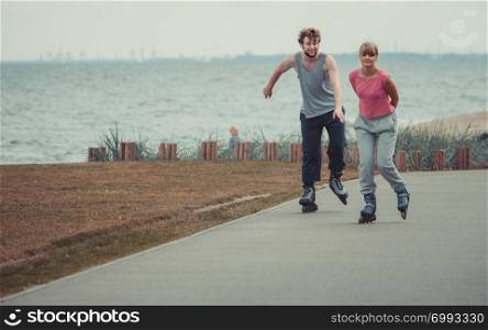 Relax leisure love romance dating sport fitness concept. Boy chasing his girlfriend. Couple spending time together skating on rollerskates. . Boy chasing his girlfriend.