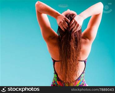 Relax, rest and recreation. Long haired woman back in colorful swimsuit on pool.