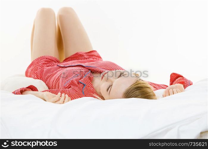 Relax rest sleep positions concept. Girl drowning in dreams. Young woman wearing red dotted pajamas lying in bed on back dreaming deeply.. Woman sleeping in bed on back