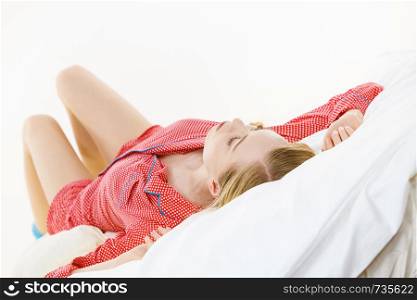 Relax rest sleep positions concept. Girl drowning in dreams. Young woman wearing red dotted pajamas lying in bed on back dreaming deeply.. Woman sleeping in bed on back