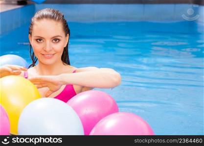 Relax, spa hotel, wellness concept. Woman having fun with balloons in water. Pretty girl relaxing at swimming pool.. Woman having fun with balloons in water pool