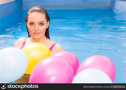 Relax, spa hotel, wellness concept. Woman having fun with balloons in water. Pretty girl relaxing at swimming pool.. Woman having fun with balloons in water pool
