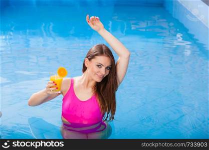 Relax, spa wellness concept. Charming woman having fun with cocktail drink alcohol. Pretty girl relaxing at swimming pool, enjoying the water. Girl with cocktail drink relaxing at swimming pool