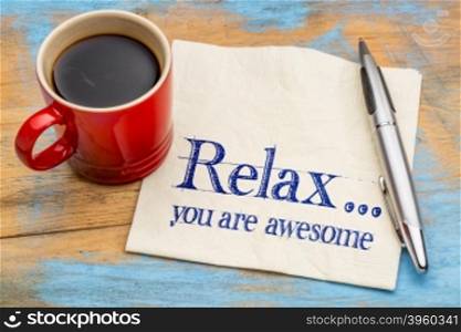 Relax, you are awesome - reminder or positive affirmation - handwriting on a napkin with cup of coffee