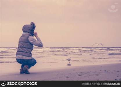 Relaxation and leisure. Woman walking on beach. Female tourist relax near to water place on nature. Autumn cold season.. Woman walking on beach, autumn cold day