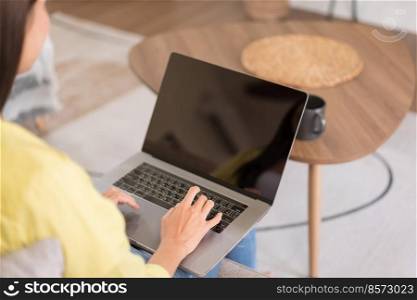 Relaxation concept, Young woman is chatting with friends on laptop while sitting on the couch.