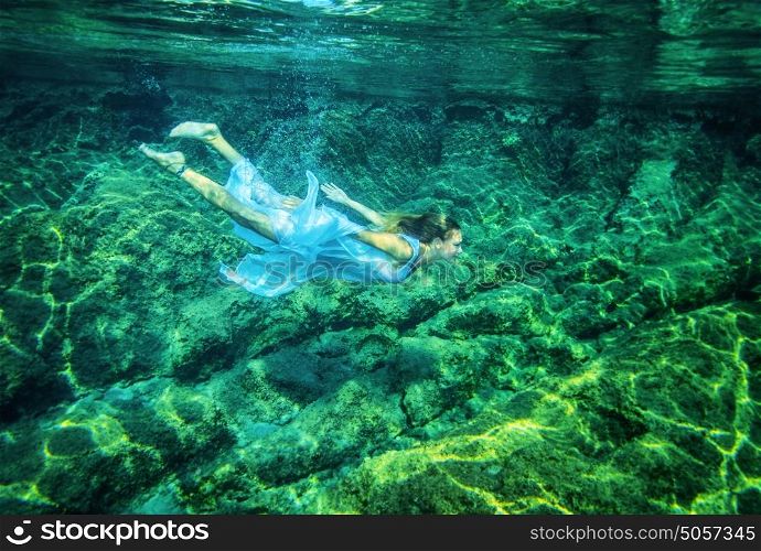 Relaxation in the sea, beautiful young female swimming underwater, summer time activity, refreshment and enjoyment concept