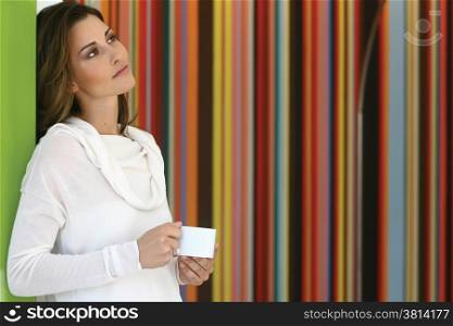 Relaxed beautiful woman drinking coffee in kitchen