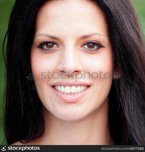 Relaxed brunette woman in the park showing her perfect smile