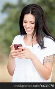 Relaxed brunette woman on the park looking at his mobile