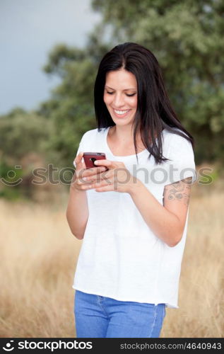 Relaxed brunette woman on the park looking at his mobile