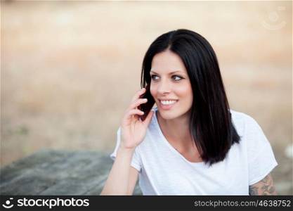 Relaxed brunette woman on the park talking on the mobile