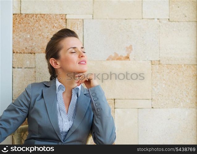 Relaxed business woman sitting on terrace