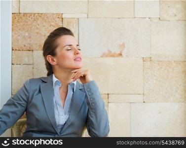 Relaxed business woman sitting on terrace
