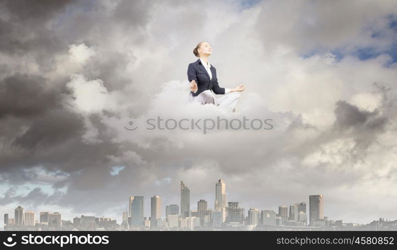 Relaxed businesswoman. Young attractive lady sitting on cloud and practicing yoga