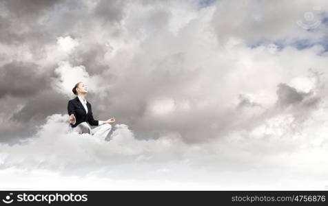 Relaxed businesswoman. Young attractive lady sitting on cloud and practicing yoga