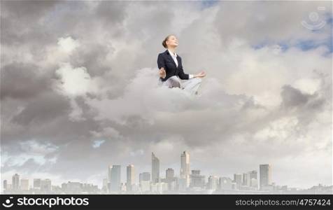 Relaxed businesswoman. Young attractive lady sitting on cloud and practicing yoga